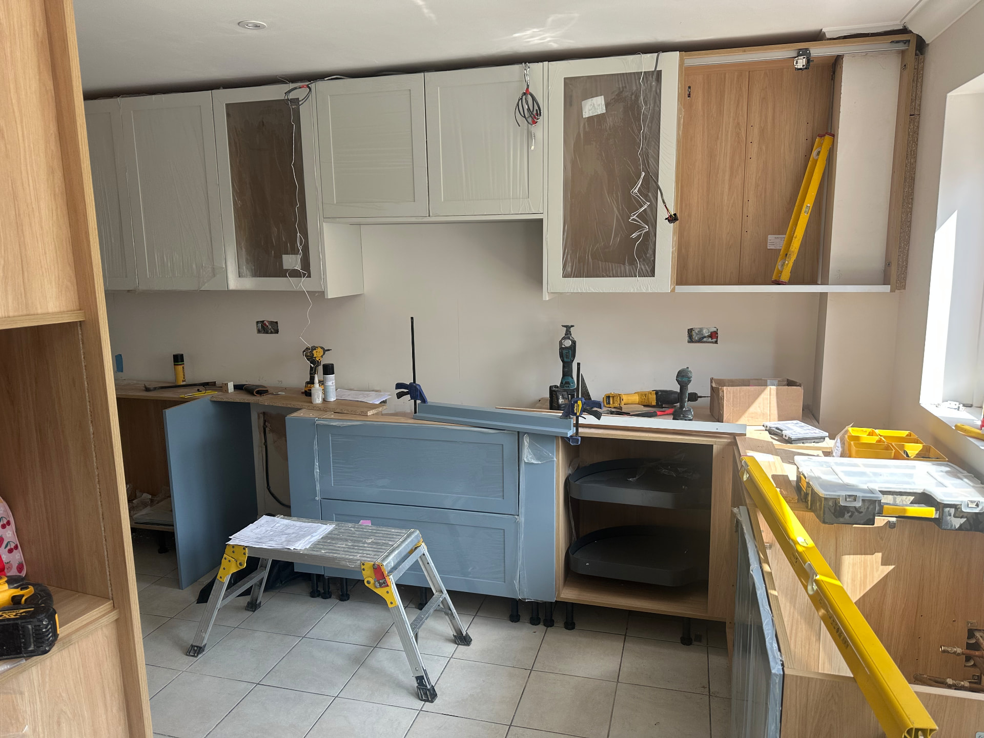 New blue-grey hand painted cabinets being fitted by our team