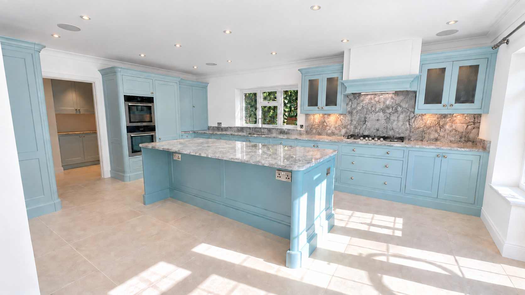 The finished duck-egg blue hand painted kitchen with island and stone worktops