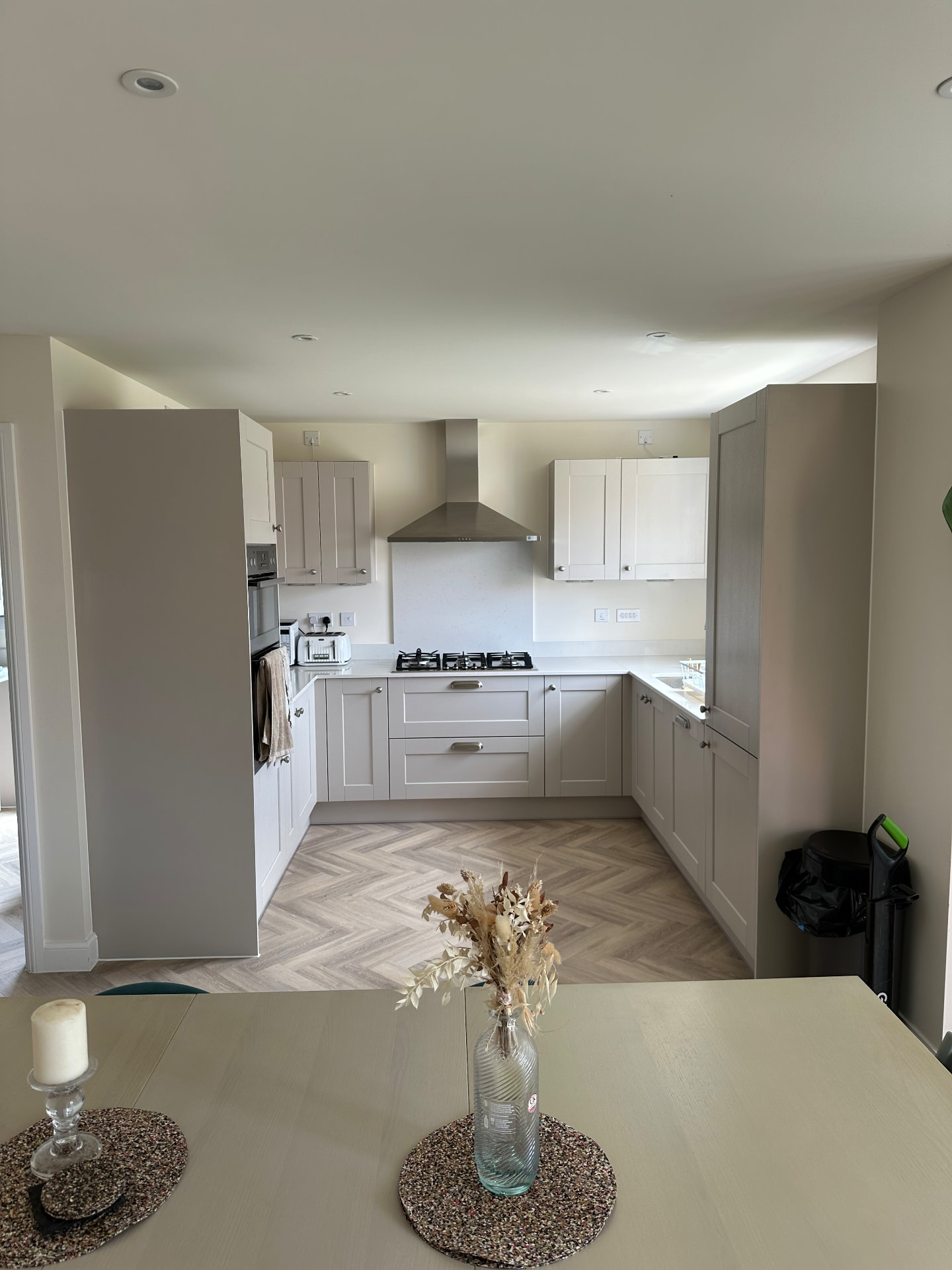 Neutral shaker kitchen viewed from the adjoining dining space
