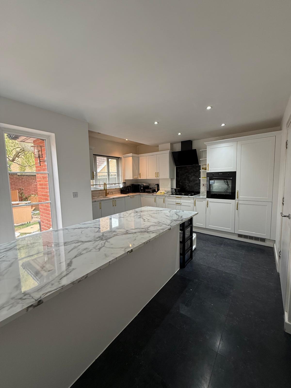 Completed white shaker kitchen seen from the room's wide angle