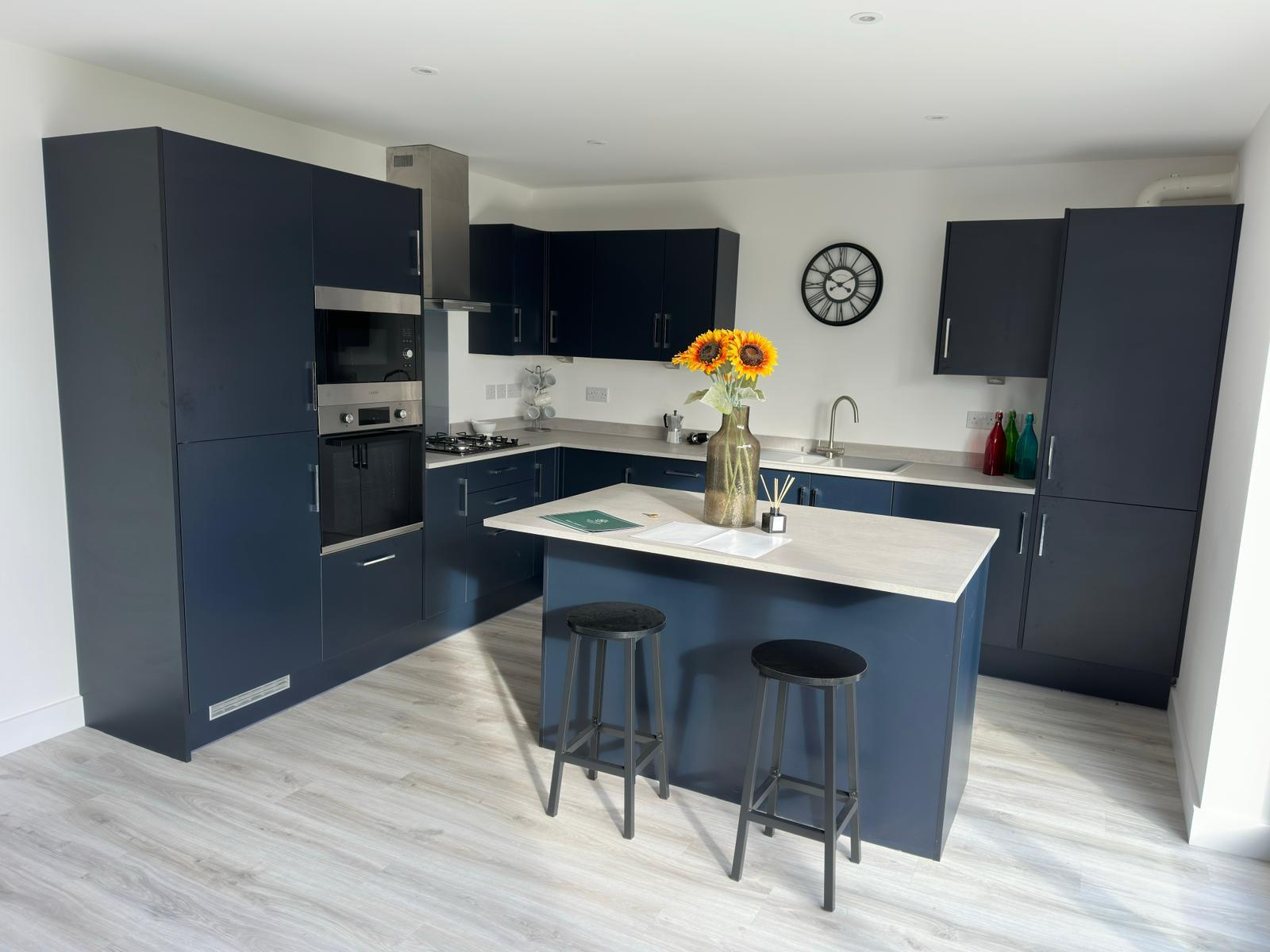 Deep navy kitchen with central island and sunflowers